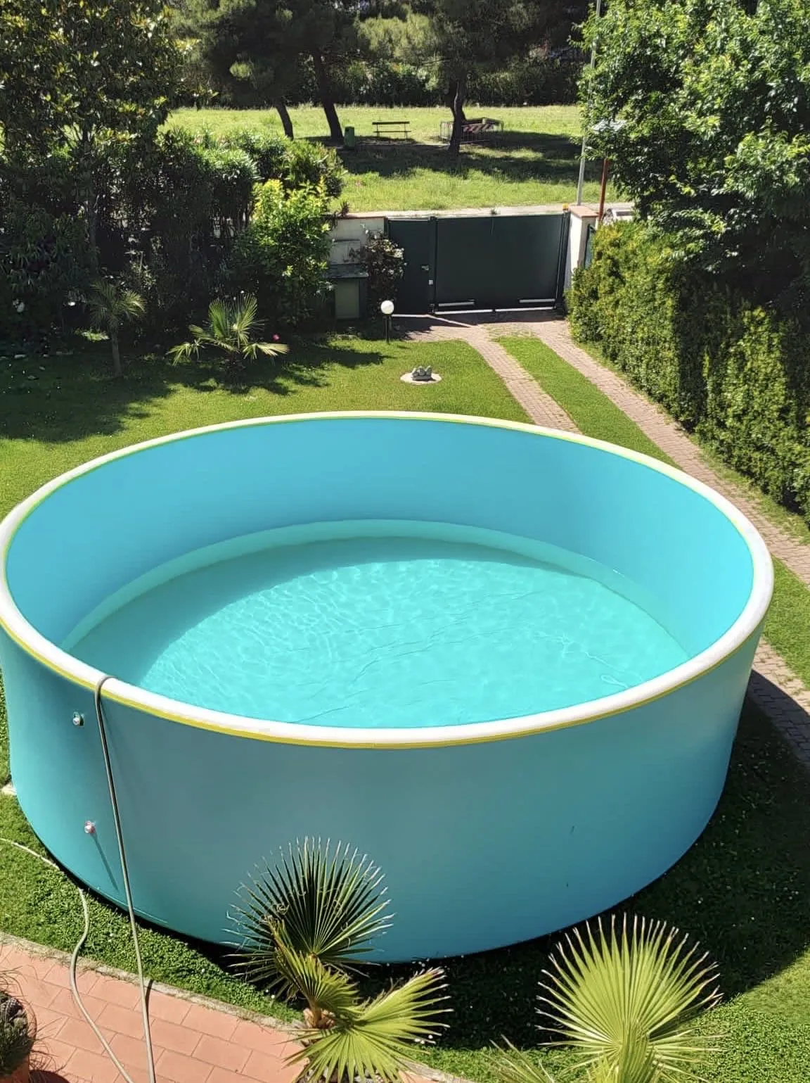 Large round portable pool in a garden